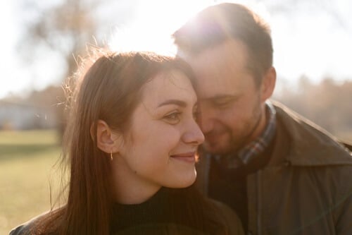 women and men in park hug with love