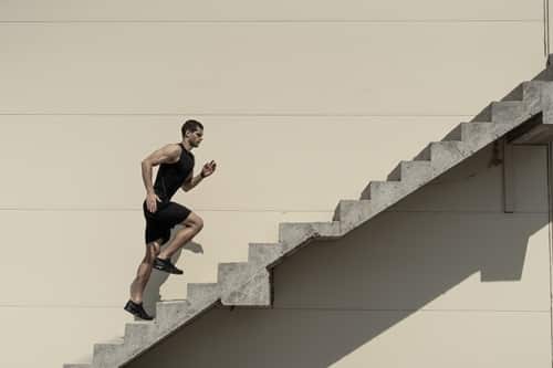 overcoming challenges. Strong man climbing stairs